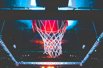 basketball hoop in red neon lights in sports arena during game