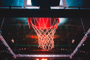 Fototapeta na wymiar basketball hoop in red neon lights in sports arena during game
