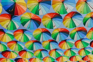 Fototapeta na wymiar Colorful razchetsetnye umbrellas against the sky, toned.