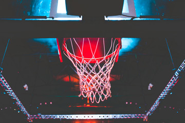 Fototapeta na wymiar basketball hoop in red neon lights in sports arena during game