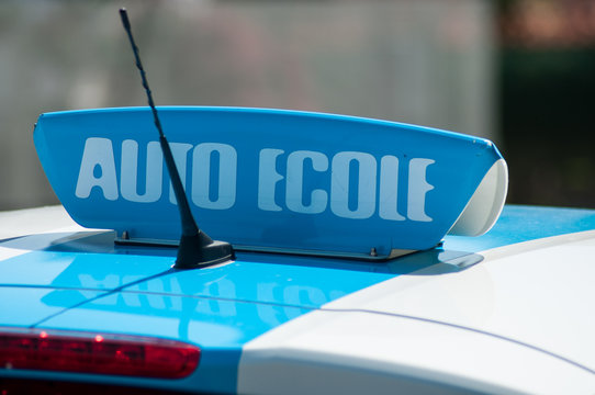 closeup of french driving school panel on the car roof , text in french "auto ecole", traduction in english "driving school"