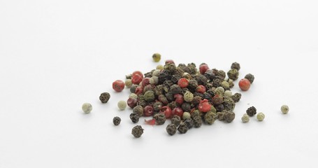 Mix of multicolored pepper. Peas with spices. Macro on white background