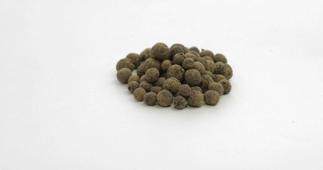 Black pepper. Peas with spices. Macro on white background