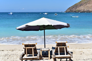 Chairs and umbrellas on a white sand Pantai Mawun beach, Lombok Island, Indonesia