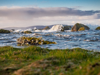 Landscape West coast of Ireland, Selective focus, Wave in focus, Burren mountains in the background.