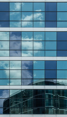 Fototapeta premium blue glass building facade with sky reflection