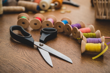 Sewing concept. Scissors and colorful thread spools.
