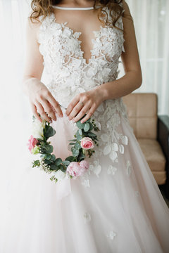 Beautiful wreath of flowers in the hands of the bride.