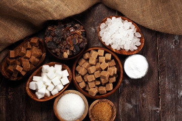 Various types of sugar, brown sugar and white on rustic wooden table