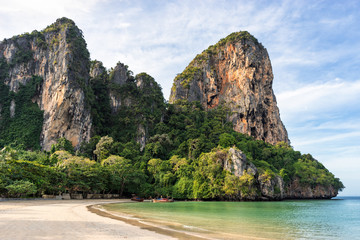 Landscape of scenic big cliffs on seashore coastline on empty West Railay Beach in the morning in Krabi in Thailand