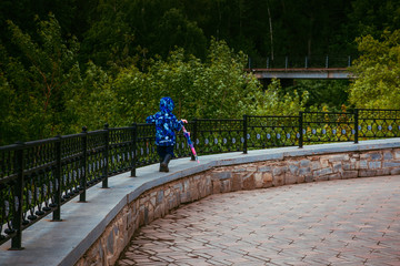 child walks with an umbrella along the promenade