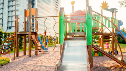 Toned image of big wooden playground with lots of ladders and slides at park