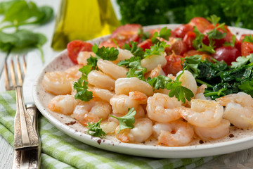 Grilled shrimps and tomatoes with spinach, garlic and parsley.