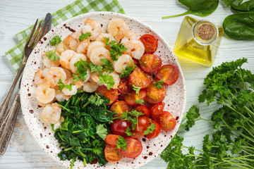 Grilled shrimps and tomatoes with spinach, garlic and parsley.