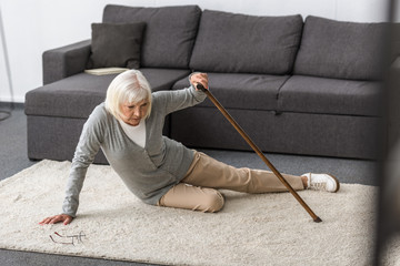suffering senior woman with heart attack on carpet
