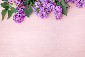 Spring Lilac flowers on pastel wooden background with copy space. Top view, flat lay
