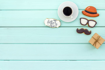 moustache, hat, glasses, coffee, gift and copy for Happy Father Day party on mint green background top view copy space