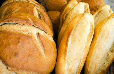 Fresh loaf of white bread. White bread on the showcase in the bakery. Hot baking. Bakery products made from wheat flour. Selective focus image, background, copy space.