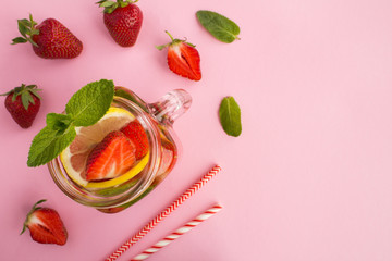 Detox or infused water with strawberry and lemon  in the glass  on the pink background.Top view.Copy space.