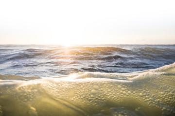 Sunrise ocean with glow and waves