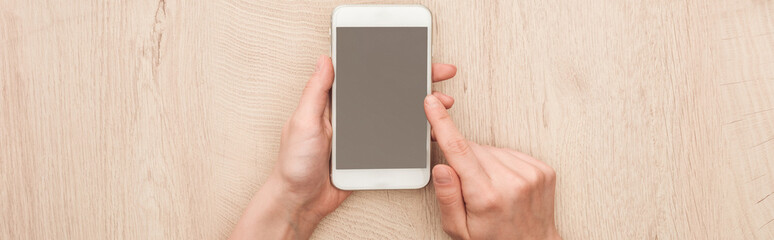 Fototapeta na wymiar panoramic shot of woman holding smartphone with blank screen
