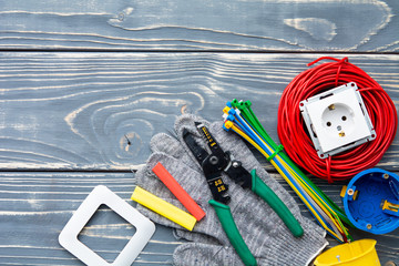 Electrician's supplies on gray wooden background