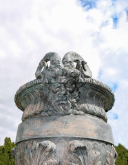 Stone vase in the old classical style with flowers in the park.