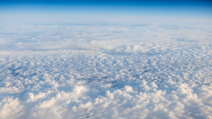 Fototapeta na wymiar The beautiful cloudscape with clear blue sky. A view from airplane window.