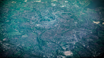 Aerial view of famous houses and roads of Amsterdam city from airplane window.
