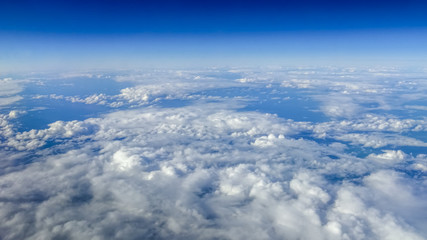 Naklejka premium The beautiful cloudscape with clear blue sky. A view from airplane window.