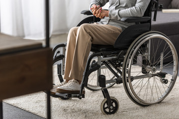 partial view of disabled senior woman in wheelchair at home - obrazy, fototapety, plakaty