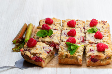 Homemade rhubarb tart with raspberry on white wooden table