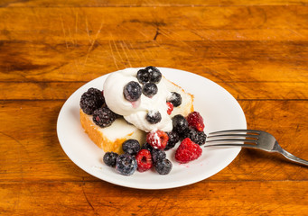 Blueberry; Blackberry and Raspberry with Whipped Cream on Pound Cake against Rustic BG