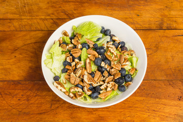Blueberry and Pecan Salad in White Bowl on Rustic Wood Table
