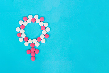 Female diseases. Female gender icon symbol made of pills on light blue background top view copy space
