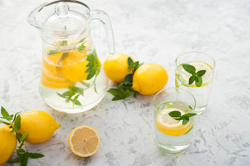 Homemade refreshing lemonade in decanter close-up and copy space. Lemonade from lemons, mint, ice.