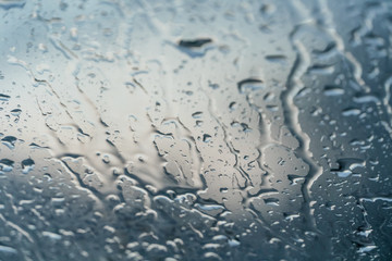 Background of water droplets on the windshield on a rainy evening with sun patterns
