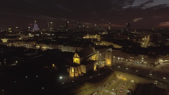 Aerial view of the buildings of the old city of Warsaw at night. royal palace and rooftops old buildings. Taken from the drone in RAW Format. 4K.