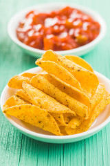 Rolled mexican nacho chips and salsa dip.