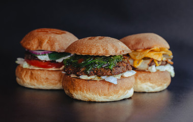 Burger flyer. Cheese burger with grilled meat, cheese, salad and onion rings. Close-up of delicious fresh home made burger with salad and cheese on bark blue background