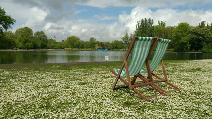 Deck chairs nearby a lake in a park of London