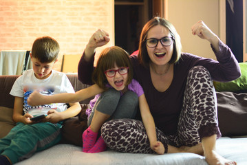 Family, sports and entertainment concept. Football fans watching soccer on tv and celebrating...
