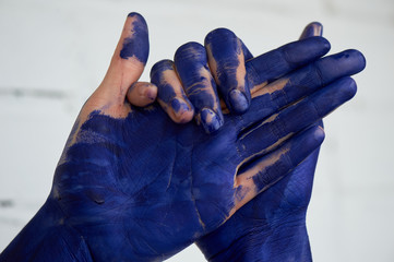 Hands in blue paint, the hands of the artist and creative person. Yoga for the hands.