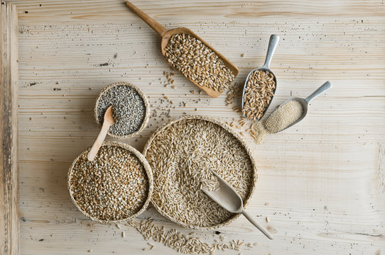 Organic wheat, rye shot, amaranth, spelt, buckwheat and oat on shovels and on wood, from above