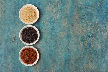 Obraz na płótnie Canvas Bowls with black, white and brown or red rice
