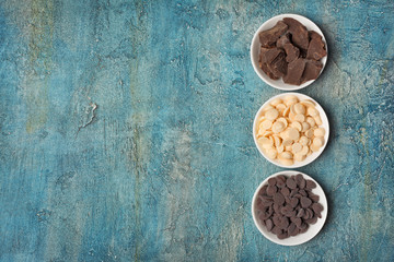 Top view of dark and white chocolate drops or morsels and chunk