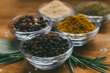 Round glass bowl with spice - black pepper in a pea.