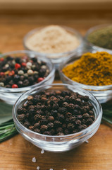 Round glass bowl with spice - black pepper in a pea.