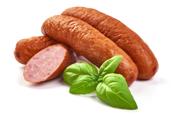 Smoked pork sausages with basil leaves, dry meat, close-up, isolated on white background