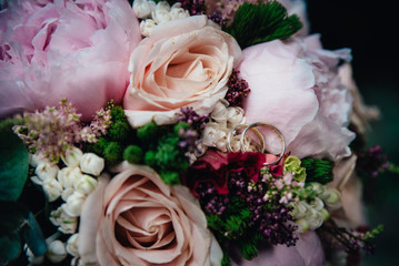 Bridal bouquet and rings on the bench.